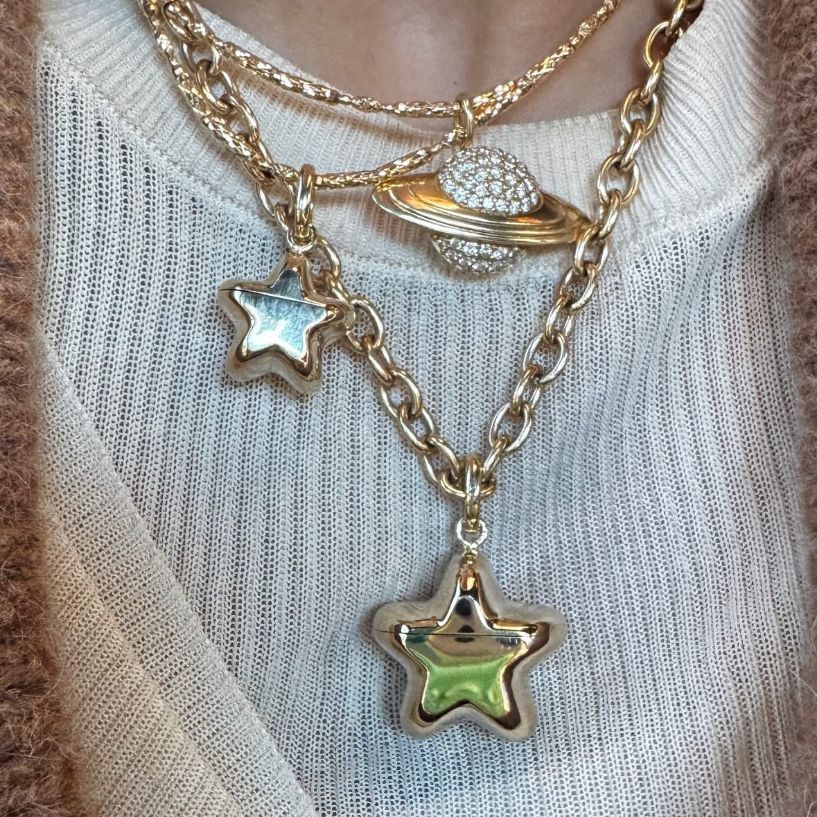 Necklace with star-shaped charms on a light-colored sweater