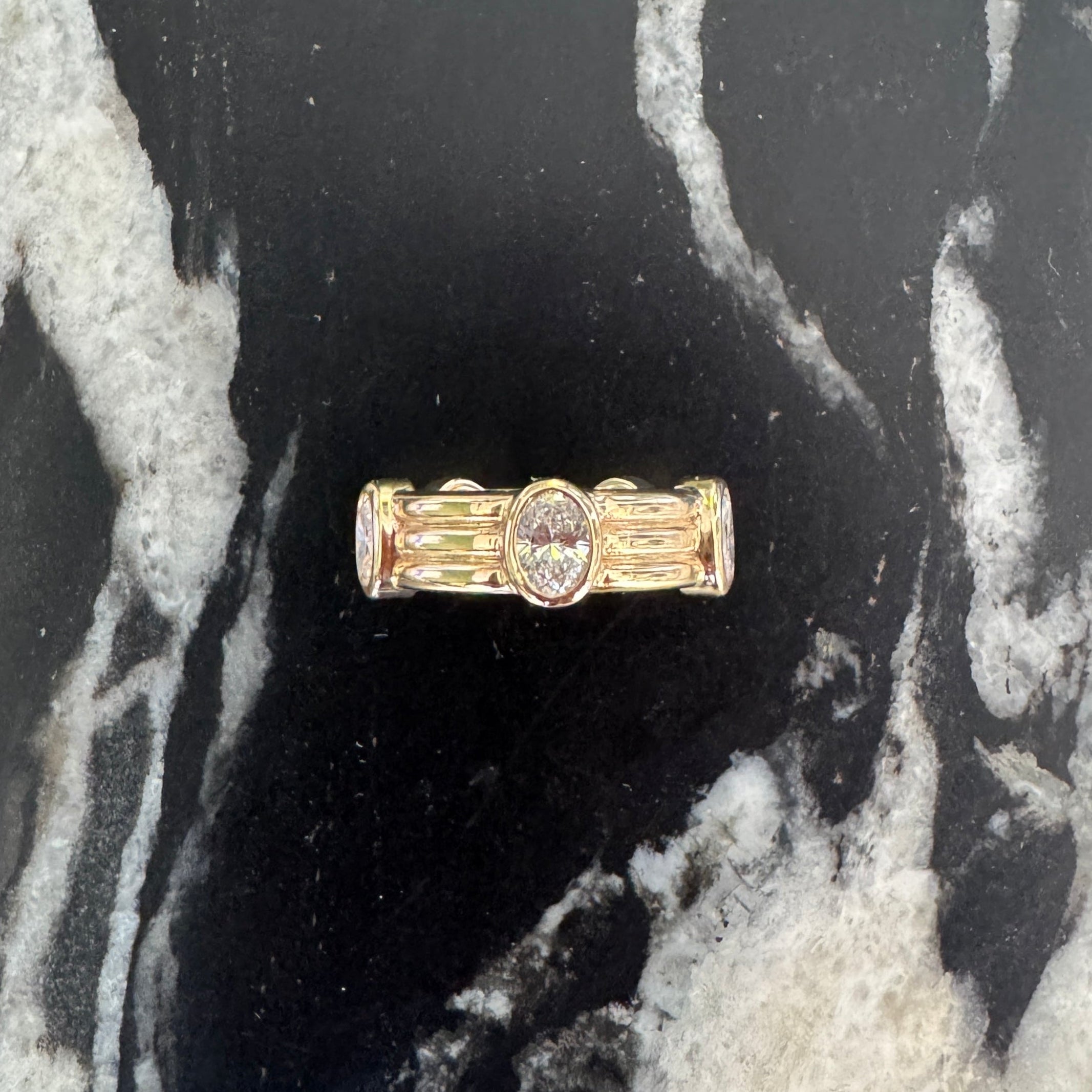 Gold ring with a diamonds on a black marble surface