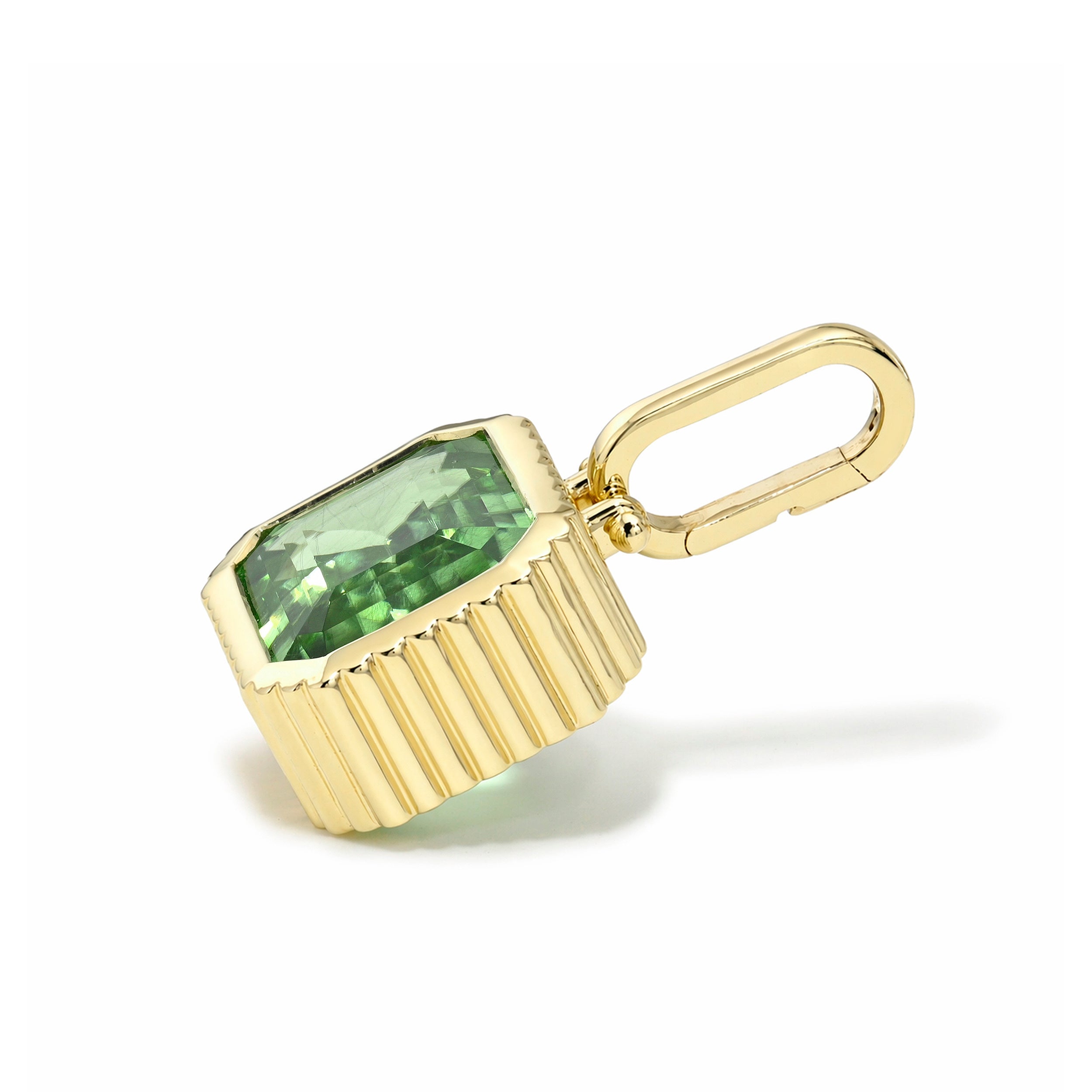 Gold pendant with a green gemstone on a white background