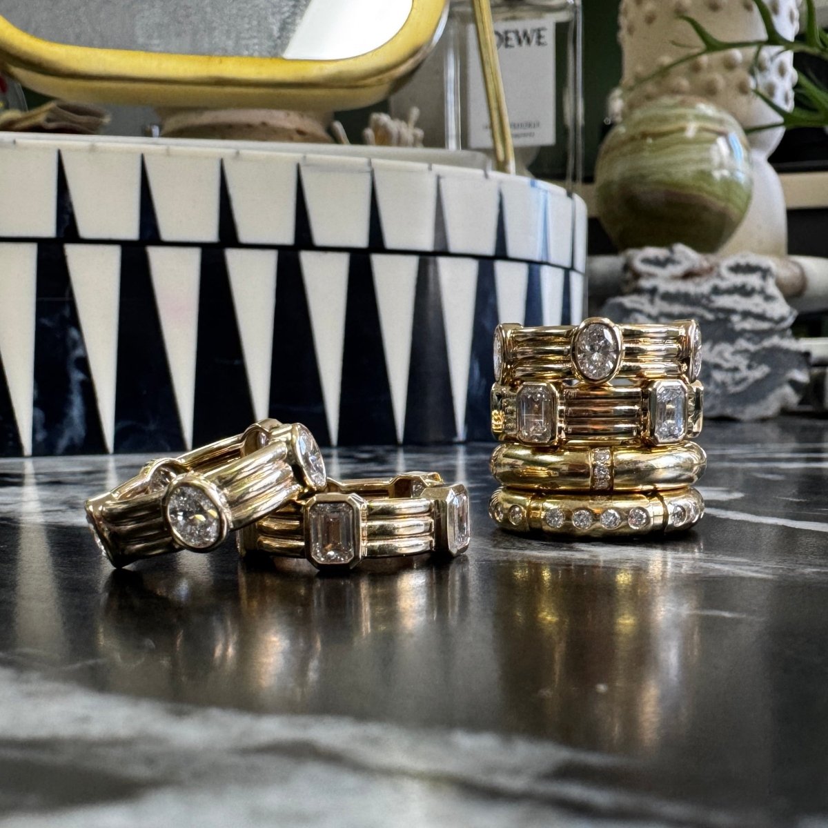 gold stacking rings with diamonds on marble surface 