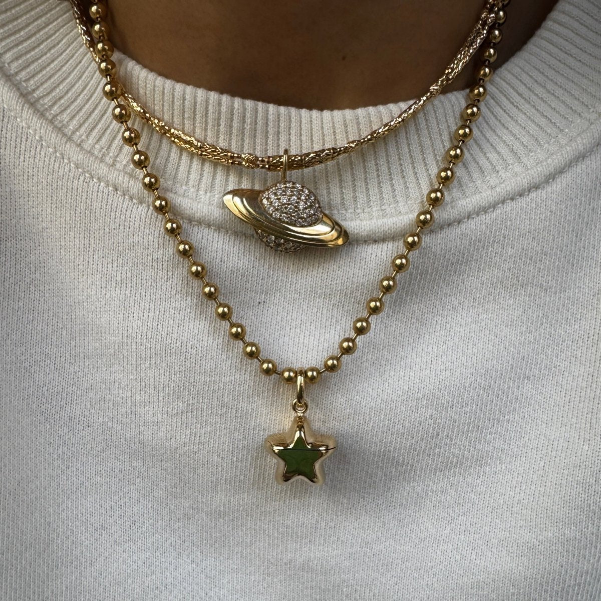 Gold necklace with star pendant on a white fabric background