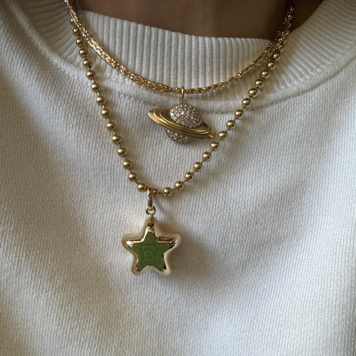 Necklace with star and planet pendants on a white background